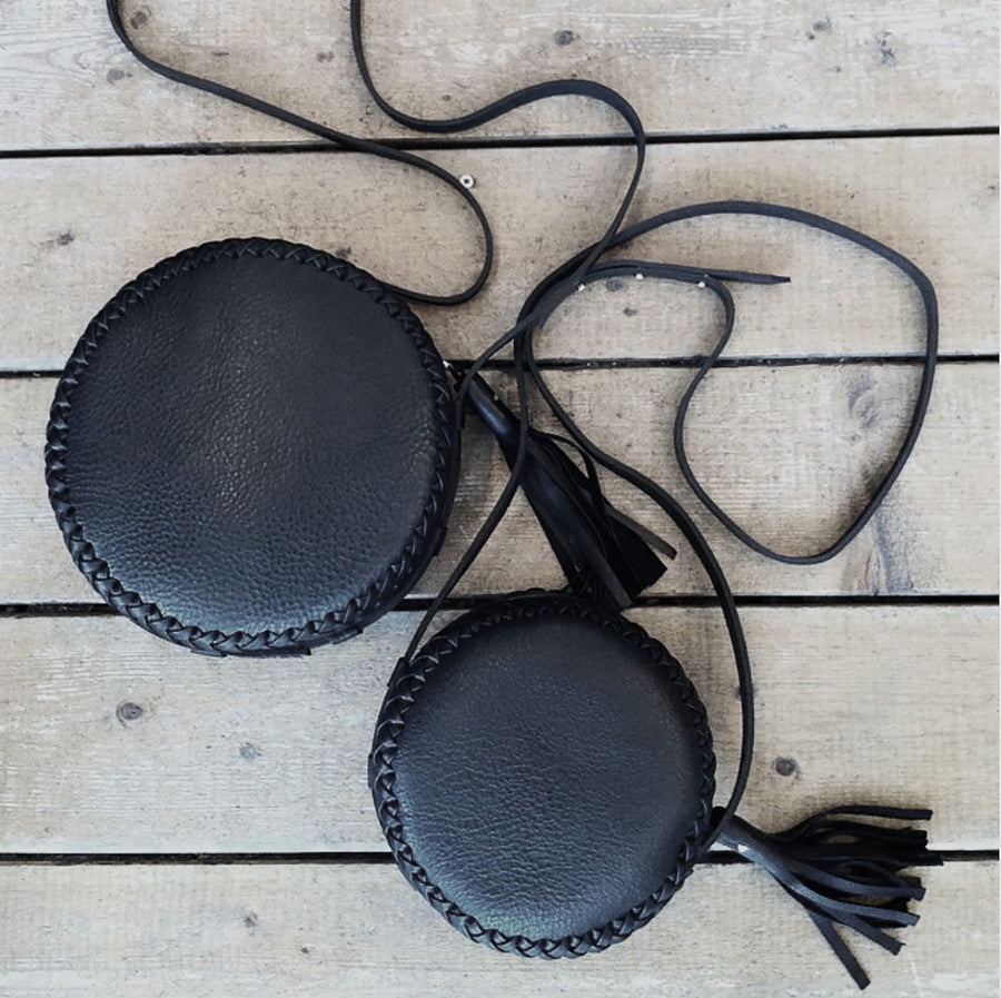 Black Leather Medium vs. Small Canteen Bag Leather Medium Canteen Bag Wendy Nichol Handbag Purse Designer Handmade in NYC New York City Circle Round Braided Adjustable strap Large Fringe Tassel Zipper pull High Quality Leather